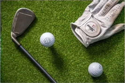 Close-up of golf clubs, balls and a glove provided with the mobile simulator