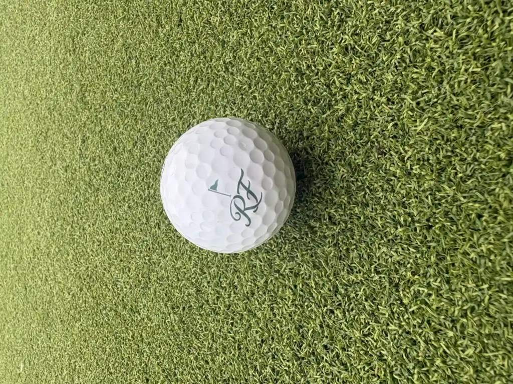 Riverside Fairways RF monogram golf ball resting on putting-green turf